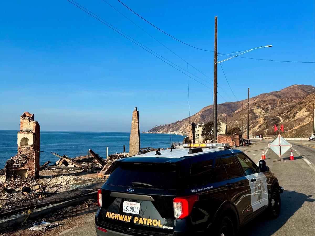 A California Highway Patrol vehicle parked at a coastal road closure.